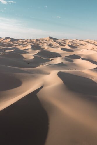 Aerial view of the expansive dunes in Samalayuca Desert, Chihuahua, Mexico under a clear sky.