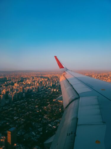 Stunning aerial view of São Paulo cityscape from airplane window during sunset.