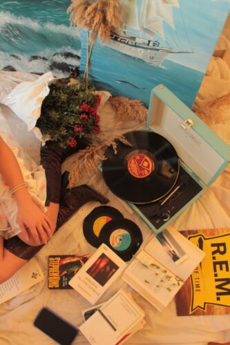 A flat lay of vintage vinyl records, books, and cozy decor for a nostalgic feel.