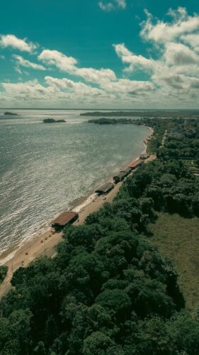 A stunning aerial view of Mosqueiro Beach in Pará, Brazil, showcasing the lush coastline and vibrant sea.