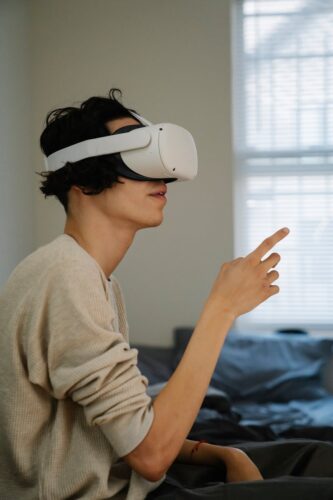 Side view of male gesticulating while experiencing virtual reality in headset in house room in daytime